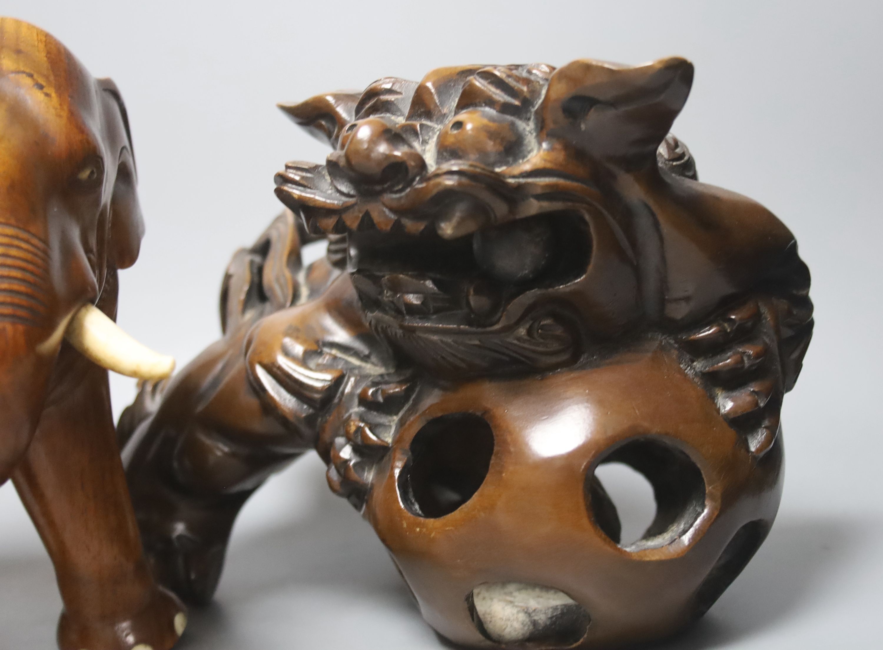 An Indian padouk wood figure of an elephant and a pair of wood figures of Buddhist lions 17cm